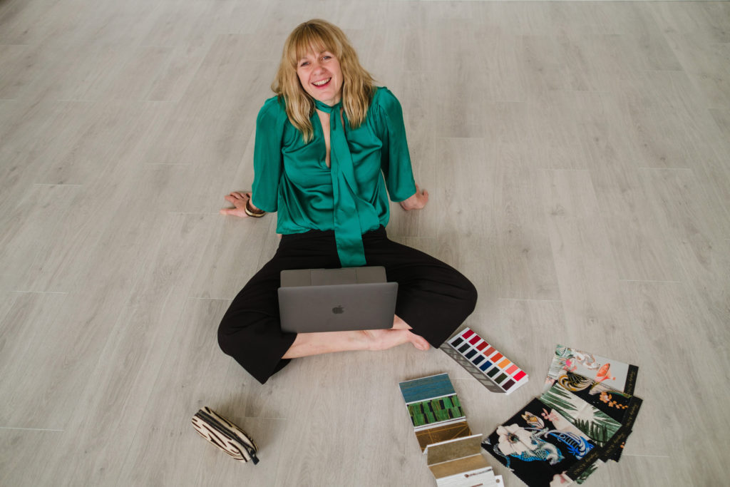 Lisa sitting on the floor surrounded by interior design swatches